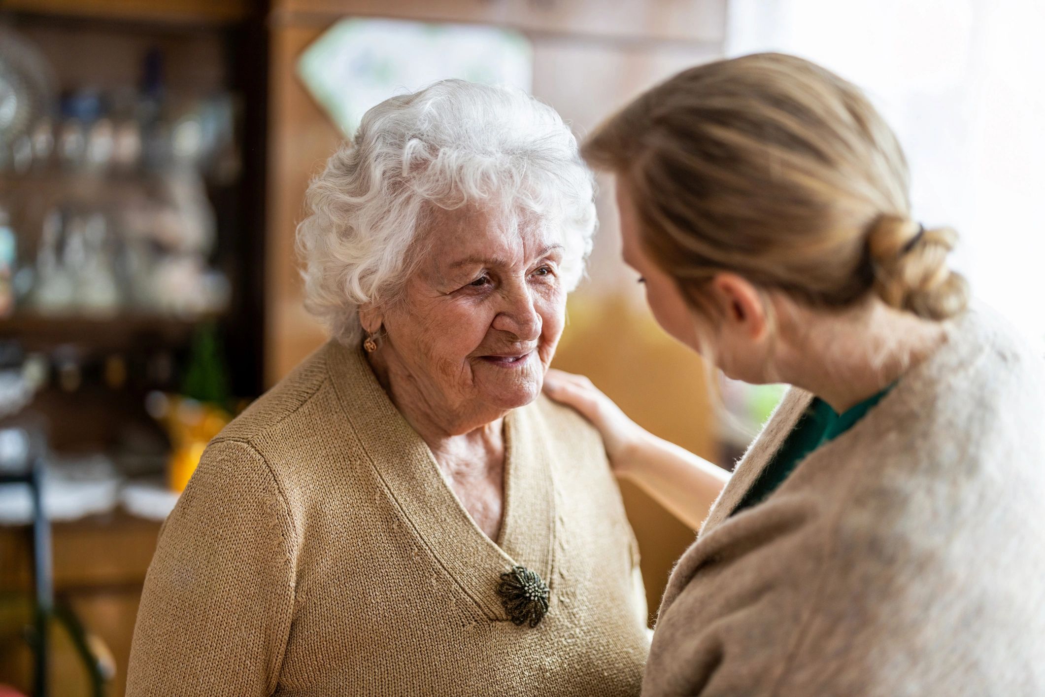 Caregiver speaking with a senior woman during a home visit
